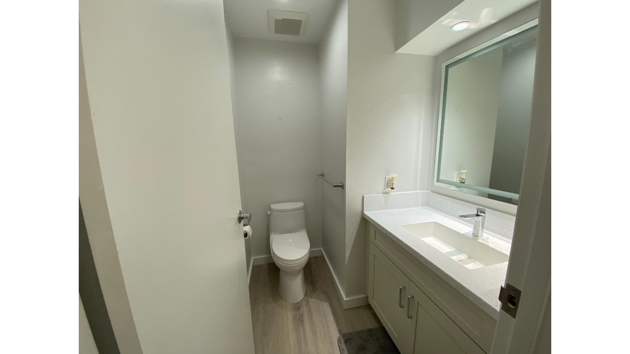 A white toilet sits next to a sink in a small bathroom.